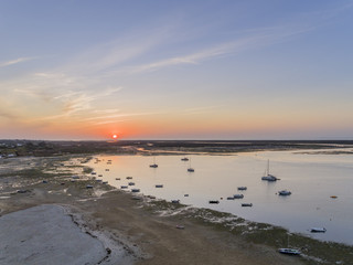 Sunrise aerial seascape, in Ria Formosa wetlands natural park, shot at 60m altitude over Cavacos beach. Algarve.