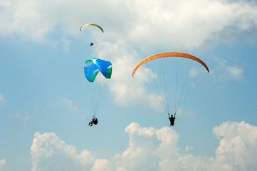 Paragliding in the blue sunny sky. Three paraglider fly in summer sunny day. Carpathians, Ukraine.