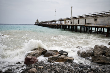 Abandoned shipping pier exposed to the forces of the sea