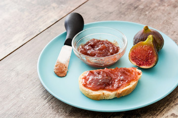 Sweet fig jam smeared on a toast on wooden table
