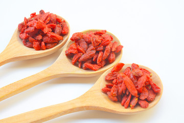 Goji berry or Chinese wolfberry in wooden spoon on white background