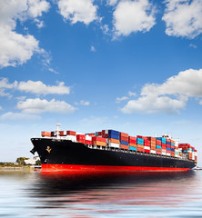 Fototapeta premium Cargo ship over blue cloudy sky