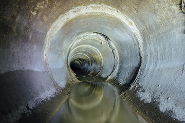 Dirty urban sewage flowing throw round sewer tunnel pipe 