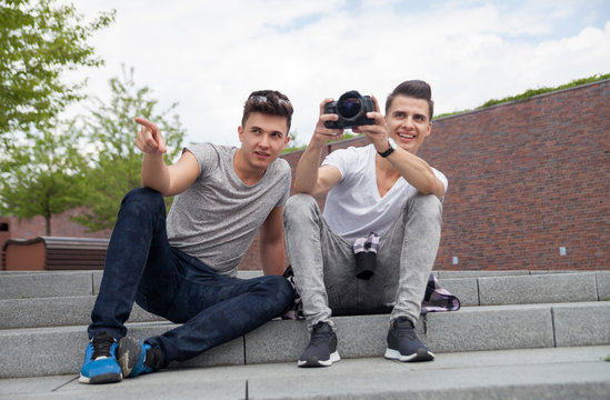 Two friends on stairs in town with camera and taking pictures, best friend