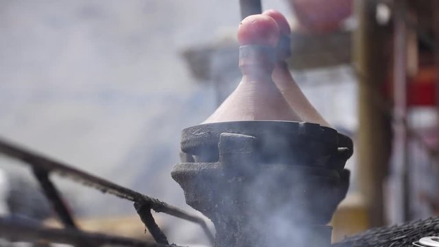 Cooking moroccan Tajine (pot) on the fire