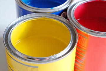 open cans of yellow, blue and red paints