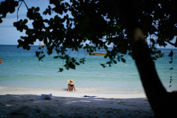 The woman sitting sunbathing beach sea happily.