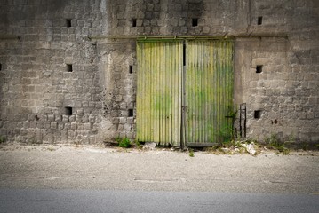 Fototapeta na wymiar Degenerated sliding door of a deserted factory building