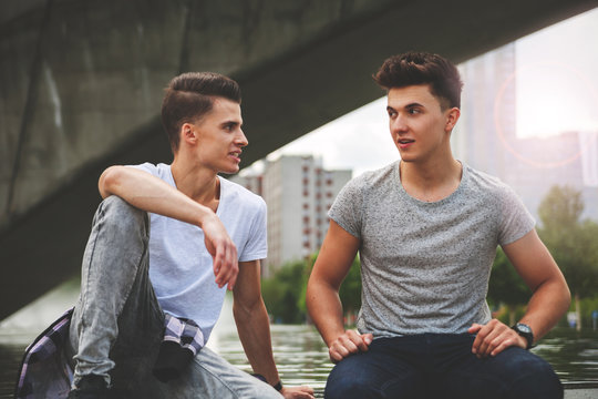 Two Friends Sitting In The City And Talking