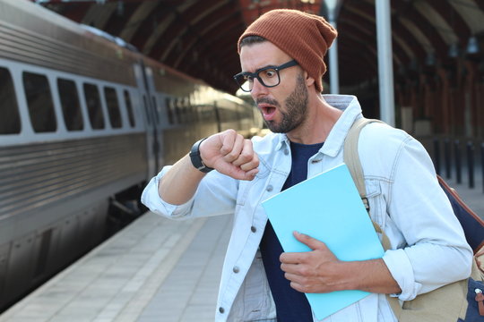 Shocked male after checking the time at the train station 