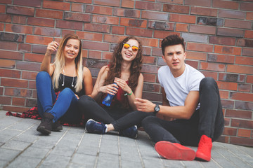 Group of young friends sitting on street and talking © leszekglasner