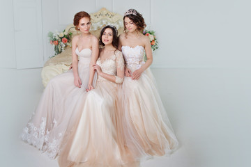 Three girls in wedding dresses. Beautiful delicate girls in the Bridal salon