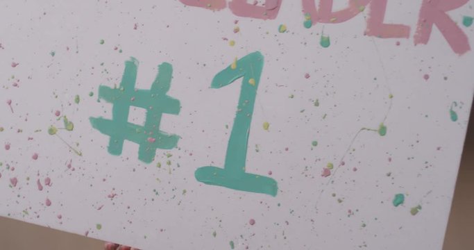 Woman holding up number 1 sign