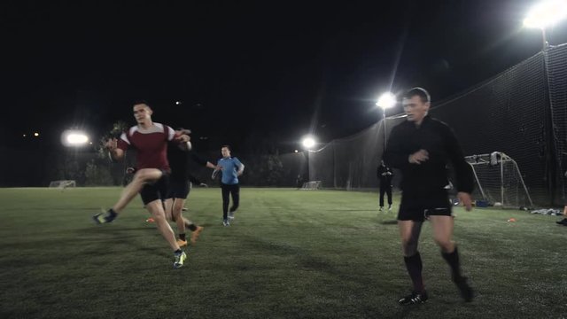 Soccer football players during the team training before the match. Exercises for football soccer youth team. Young player exercises with ball and marker cones, running training rugby men athlete