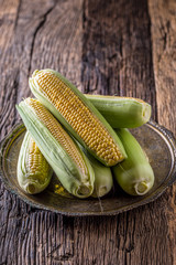 Corn. Fresh corn on old rustic oak table