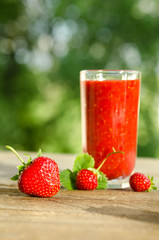  strawberries and strawberry cocktail smoothie on a wooden table