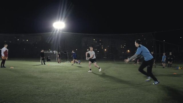 Soccer football players during the team training before the match. Exercises for football soccer youth team. Young player exercises with ball and marker cones, running training rugby men athlete