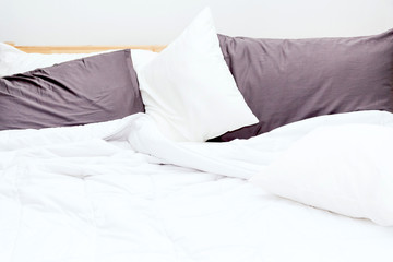 Messy bed and white bedding sheets and pillow