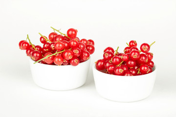 Fresh red currants in bowl on a white background close up