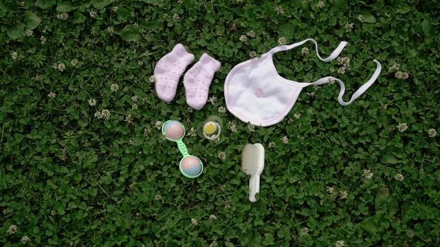 Baby booties, bib rattle on grass