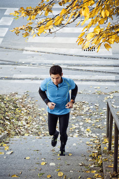Male runner jogging up staircase