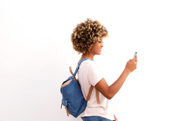 Side portrait of african american female looking at smart phone against white background