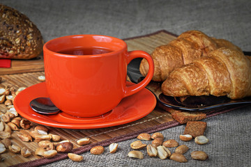 Orange cup of tea and croissants