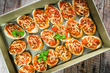 Plate with food, italian bruschetta with tomatoes and basil, spicy appetizers for party or sharing with friends