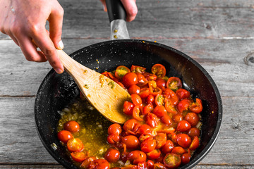 Person cooking dinner for italian cuisine, basic tomato sauce for pasta, healthy food making, detailed view of hands and pan