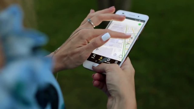 A woman holding a smartphone with a city map. A smartphone screen with a GPS navigator card.