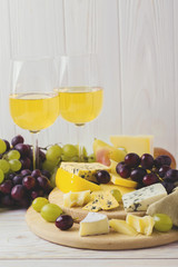 Cheese plate served with wine, fresh grapes and pears