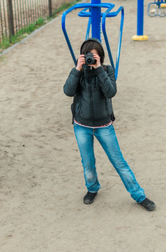 The girl the brunette to play sports on exercise machines. Exercise machines on the platform on the street