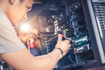The technician hold the screwdriver for repairing the computer. the concept of computer hardware, repairing, upgrade and technology.
