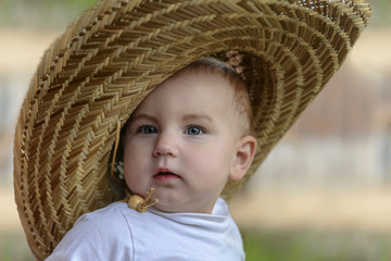 small cute fashionable child, in a large straw hat