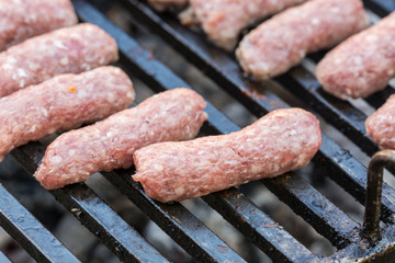 Selective focus minced meat kebabs frying on the barbecue grill