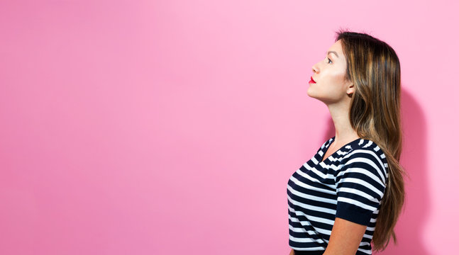 Young woman standing on a pink background