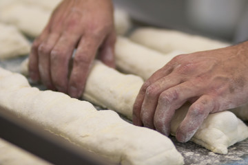 Homem fazendo pão francês em padaria no Brasil foco seletivo