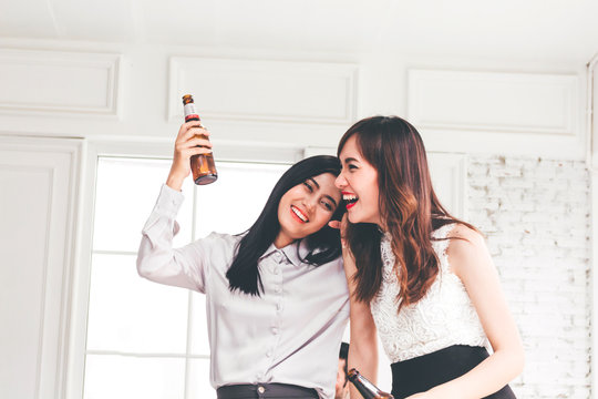 Two female friends enjoying drinking beer