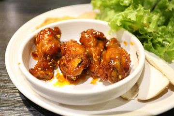 fried drum chicken with spicy sauce on white bowl
