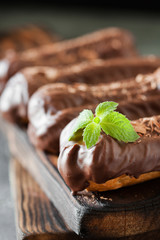 Chocolate eclair decorated with mint and melted chocolate