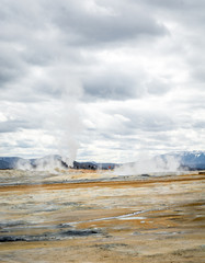 Mudpot in the Namafjall geothermal area, Iceland - area around boiling mud is multicolored and cracked