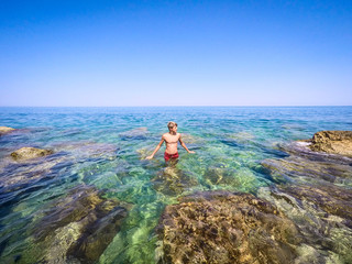 teenager ready to swim in the sea - summertime - Sicily mediterranean sea