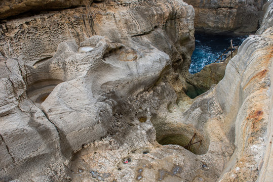Holes excavated by water in Wied il Mielah canyon. Gozo, Malta