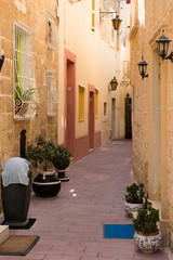 Narrow medieval street with stone houses in Mdina, Malta