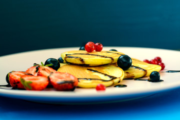 Pancake with berries and chocolate-doping on the pink plate