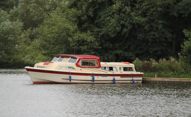 A River Cruising Holiday Boat Moored at a Bank.