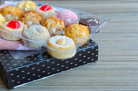 Different Panellets on wooden background. Typical sweets consumed at All Saints Day (Dia Todos Los Santos)  in Catalonia, Spain. Catalan  cakes or cookies made mainly of marzipan rolled in pine nuts.