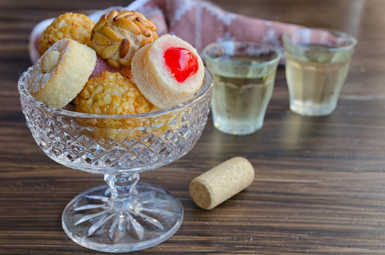 Different Panellets with two glass of sweet vine. Typical sweets consumed at All Saints Day (Dia Todos Los Santos)  in Catalonia, Spain. Catalan small cakes  background.