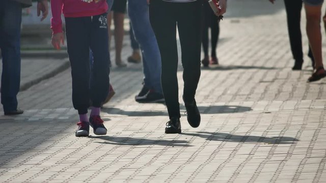 Front end loader dumping construction garbage stone and sand in a mining quarry. Yellow excavator on new construction site. people crossing the street