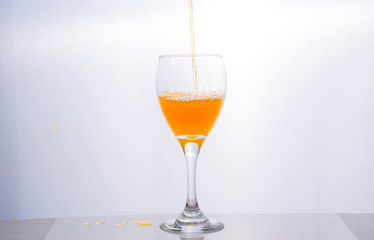 Orange juice splashing out of glass., Isolated white background.